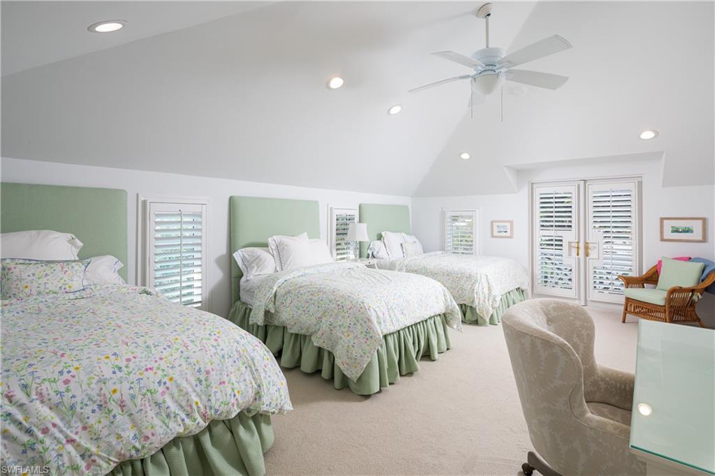 485 Wedge Drive Naples, FL 34103 - Photo 16 of 25 a spacious bedroom with two beds and a chandelier