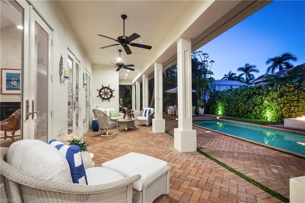 485 Wedge Drive Naples, FL 34103 - Photo 21 of 25 a living room with patio furniture and a garden
