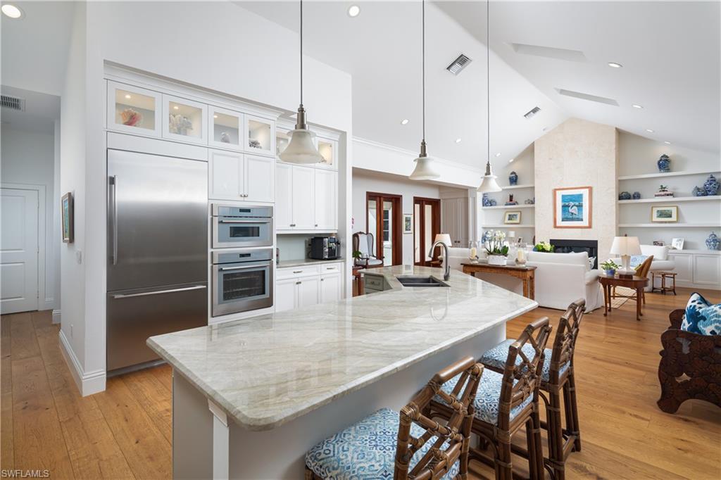 485 Wedge Drive Naples, FL 34103 - Photo 6 of 25 a kitchen with stainless steel appliances granite countertop a kitchen island a stove a table and chairs