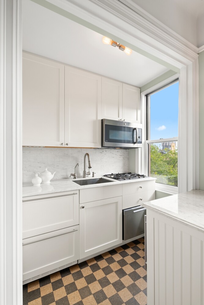 70 Remsen Street, Unit 7H Brooklyn, NY 11201 - Photo 3 of 13 a kitchen with stainless steel appliances granite countertop a sink stove and microwave