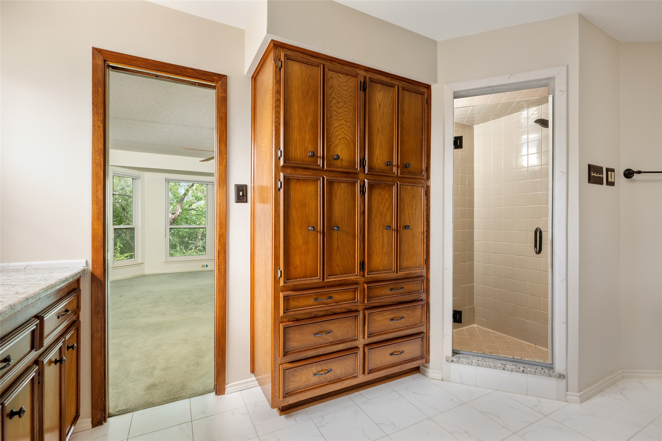 5319 Musket Ridge Austin, TX 78759 - Photo 22 of 39 Ample built-in storage and a tiled walk-in shower elevate this practical bathroom space.