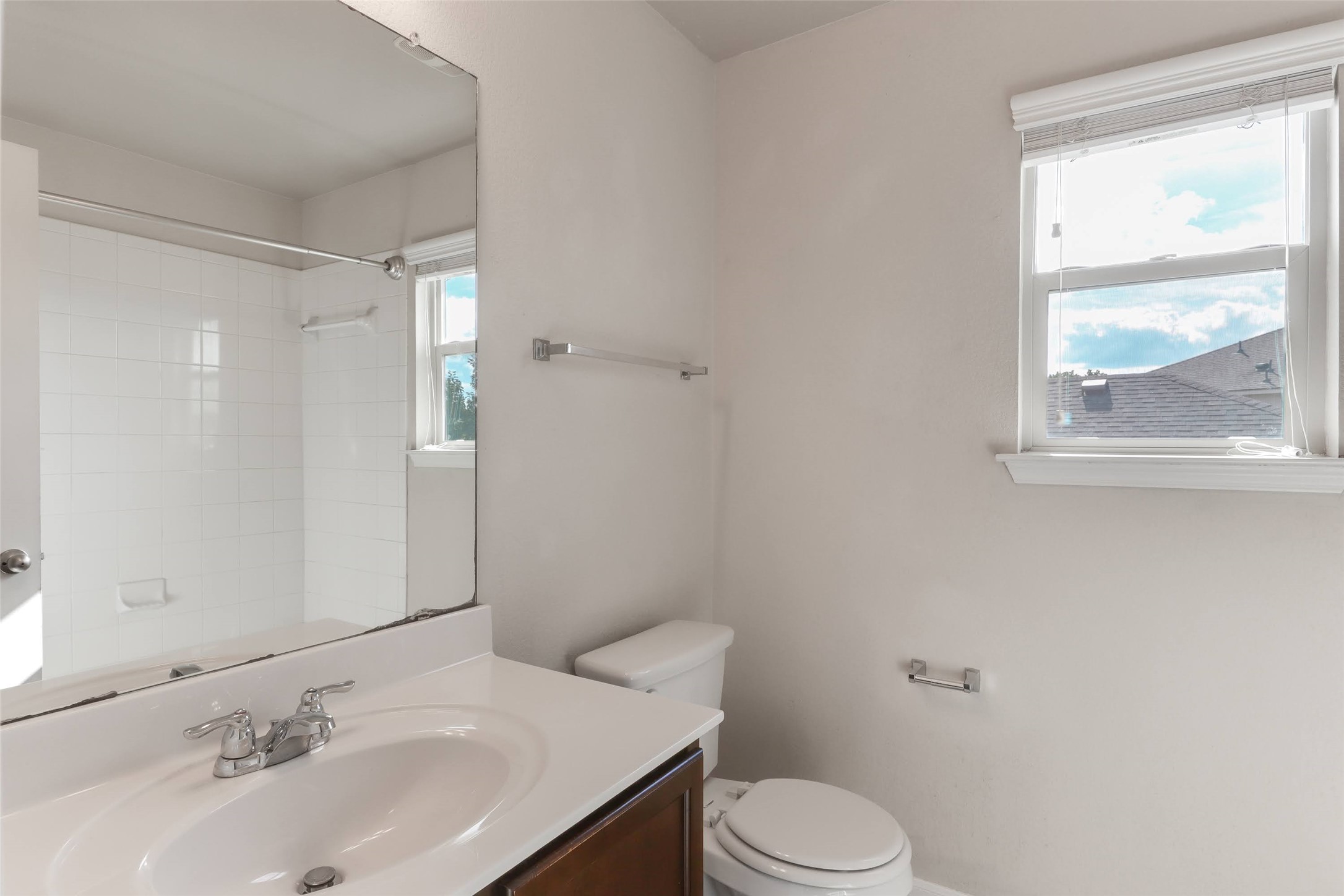 18705 Moreto Loop Pflugerville, TX 78660 - Photo 15 of 21 A well-lit bathroom features a vanity, toilet, and bathtub with clean tile surround.