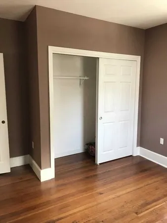 an empty room with wooden floor and a window
