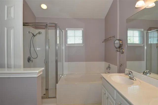 a bathroom with a tub sink and mirror