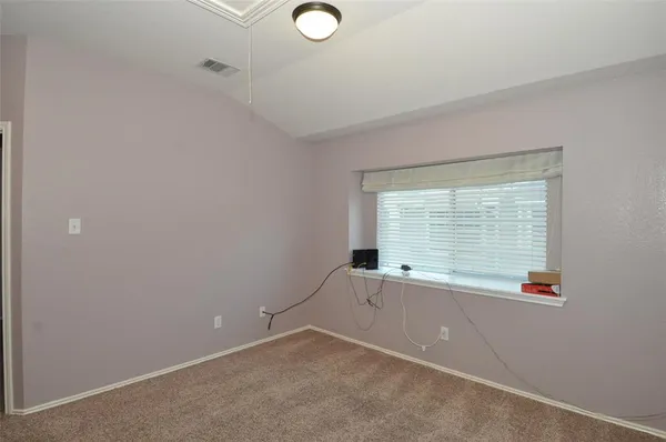 an empty room with ceiling fan and window