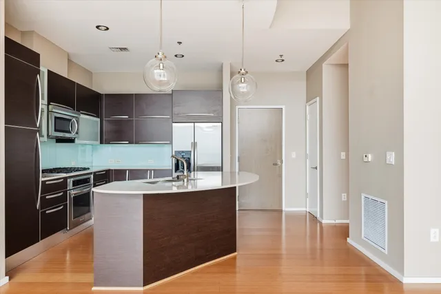 a kitchen with stainless steel appliances granite countertop a refrigerator and a stove