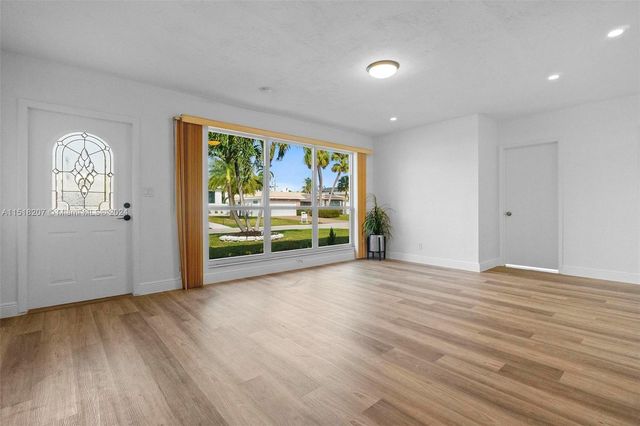 a view of a kitchen with wooden floor and electronic appliances