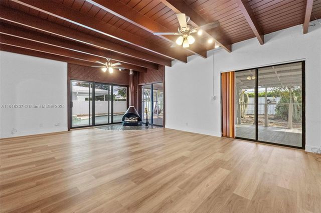 a view of a yoga room with wooden floor and a glass door