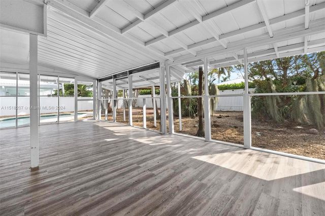 a view of empty room with wooden floor and windows