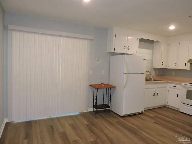 a kitchen with white cabinets and white appliances
