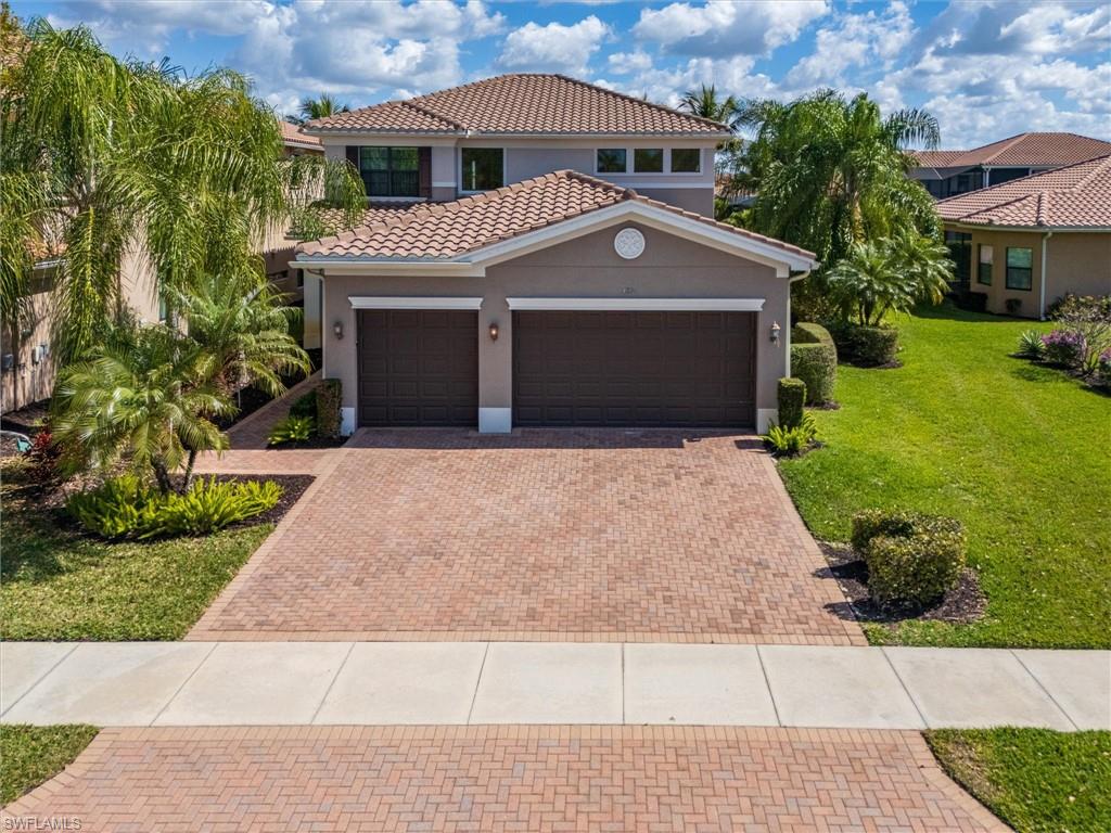 3296 Pacific Drive Naples, FL 34119 - Photo 1 of 50 a front view of a house with a garden and trees