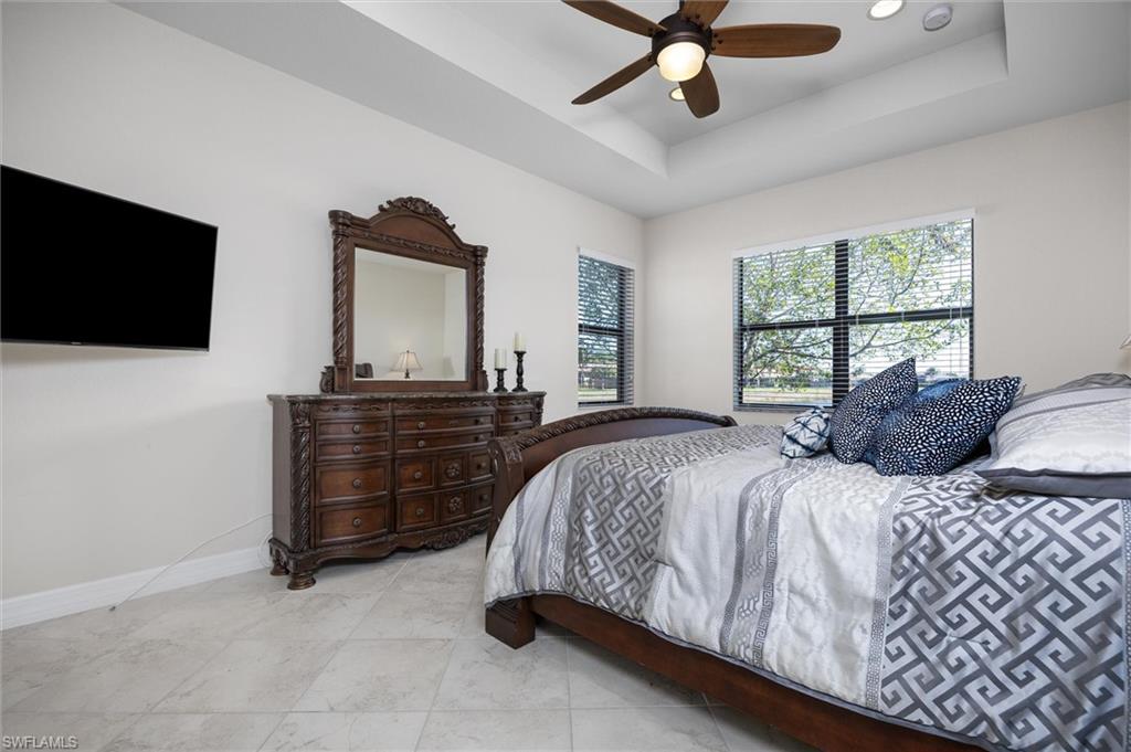 3296 Pacific Drive Naples, FL 34119 - Photo 12 of 50 a bedroom with a bed and a flat screen tv