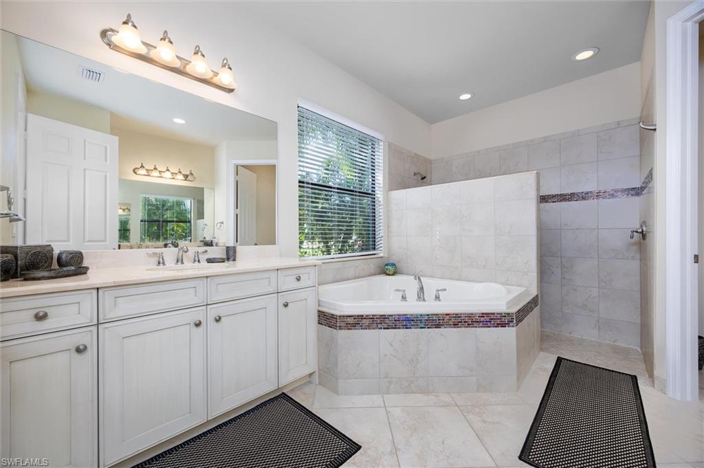 3296 Pacific Drive Naples, FL 34119 - Photo 13 of 50 a bathroom with a sink double vanity mirror and bathtub