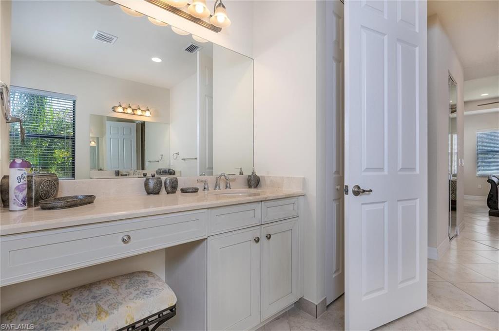 3296 Pacific Drive Naples, FL 34119 - Photo 15 of 50 a bathroom with a sink and a mirror