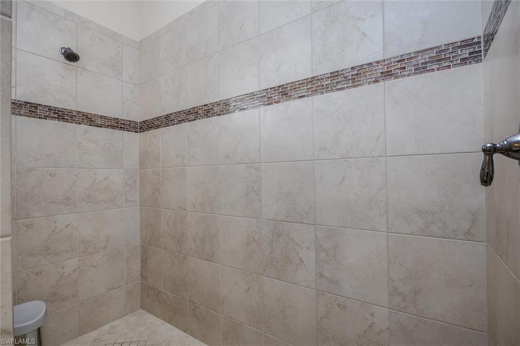 3296 Pacific Drive Naples, FL 34119 - Photo 16 of 50 a bathroom with a shower and a white bath tub
