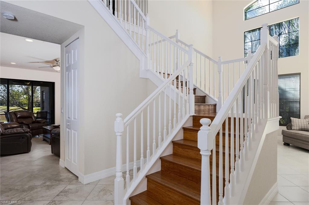 3296 Pacific Drive Naples, FL 34119 - Photo 22 of 50 a view of staircase with lots of frames on wall and a view of a hallway