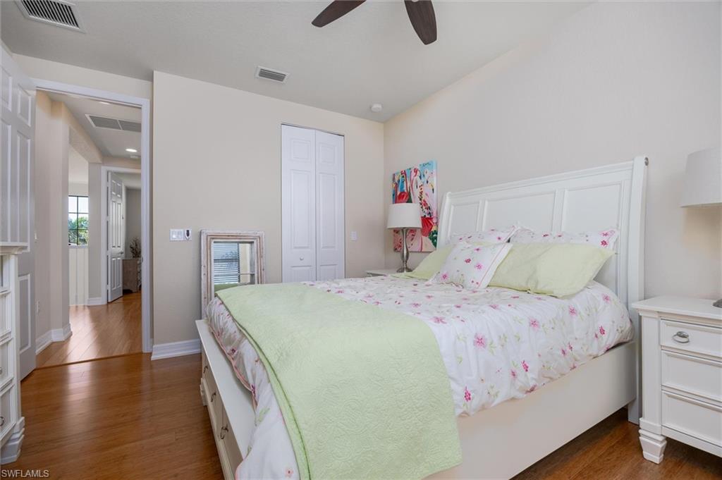 3296 Pacific Drive Naples, FL 34119 - Photo 25 of 50 a bedroom with a bed and a chandelier