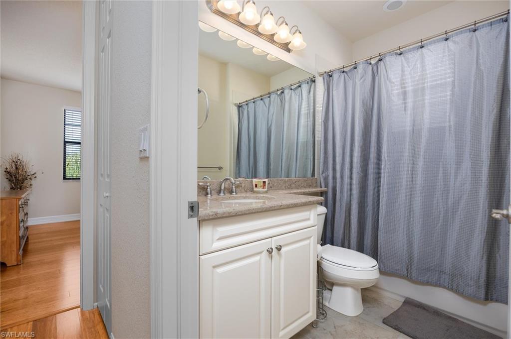 3296 Pacific Drive Naples, FL 34119 - Photo 29 of 50 a bathroom with a granite countertop sink a toilet and shower