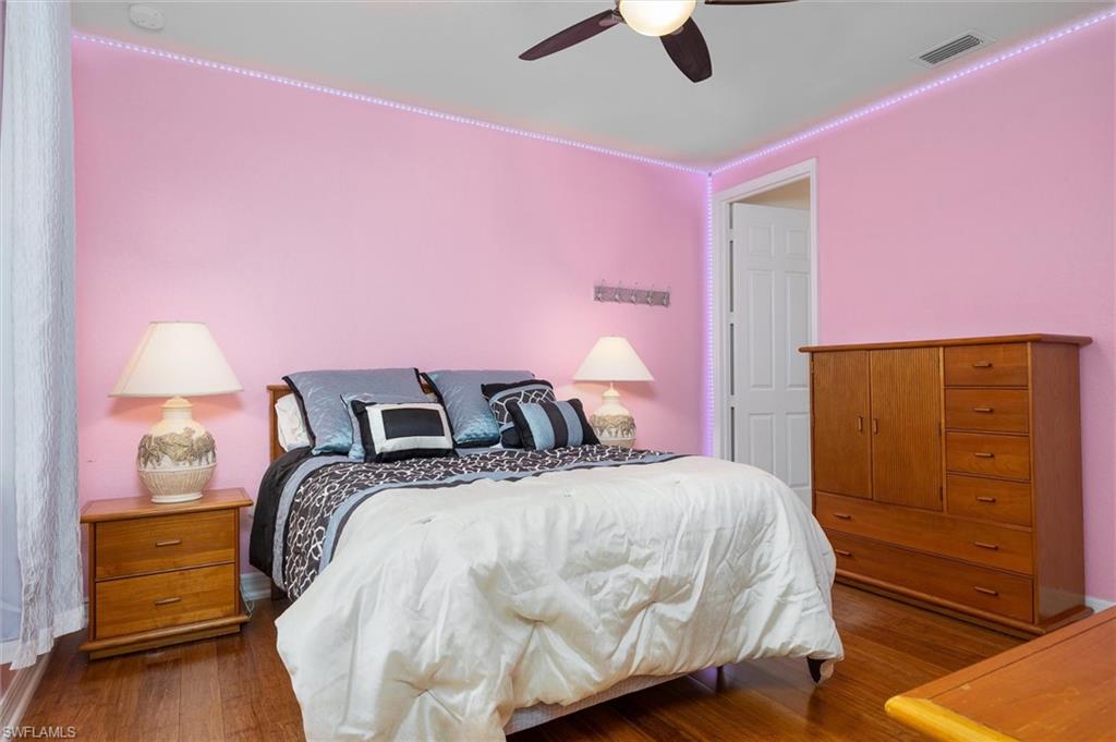3296 Pacific Drive Naples, FL 34119 - Photo 30 of 50 a bedroom with pink walls and dresser