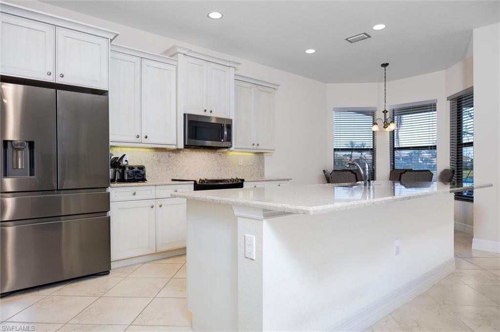 3296 Pacific Drive Naples, FL 34119 - Photo 4 of 50 a kitchen with stainless steel appliances a refrigerator sink and microwave