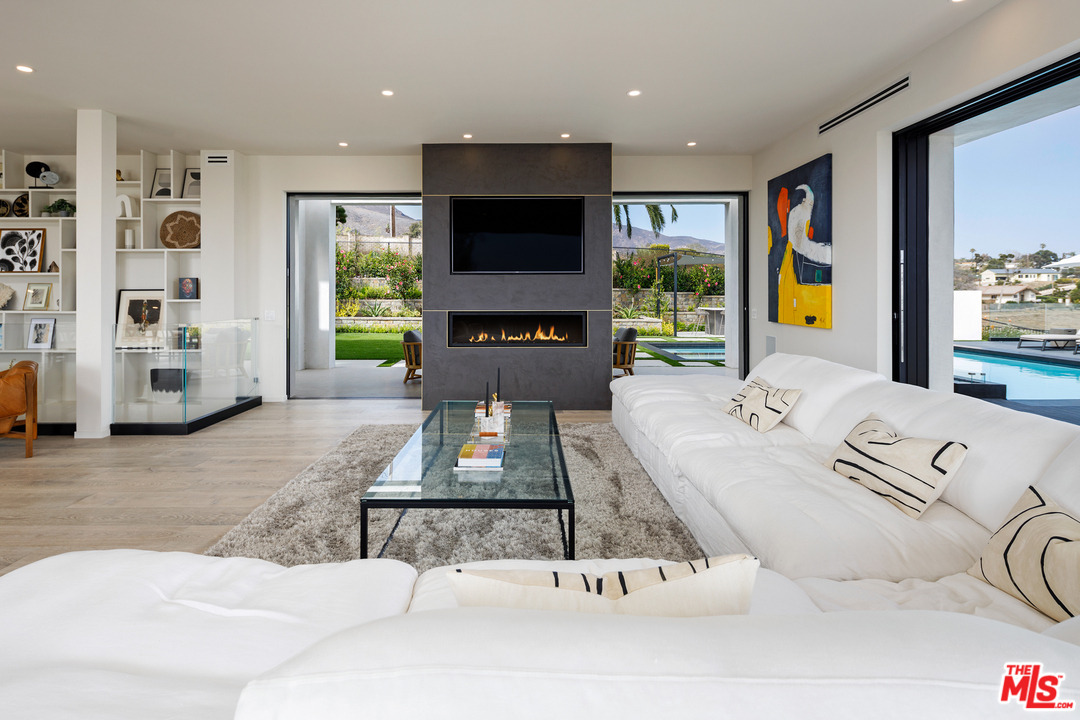 5944 Filaree Heights Road Malibu, CA 90265 - Photo 9 of 33 a living room with furniture flat screen tv and a large window