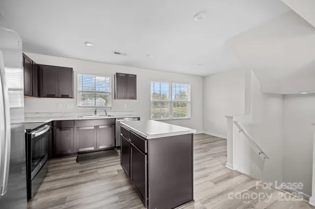 a kitchen with a sink stove top oven and refrigerator