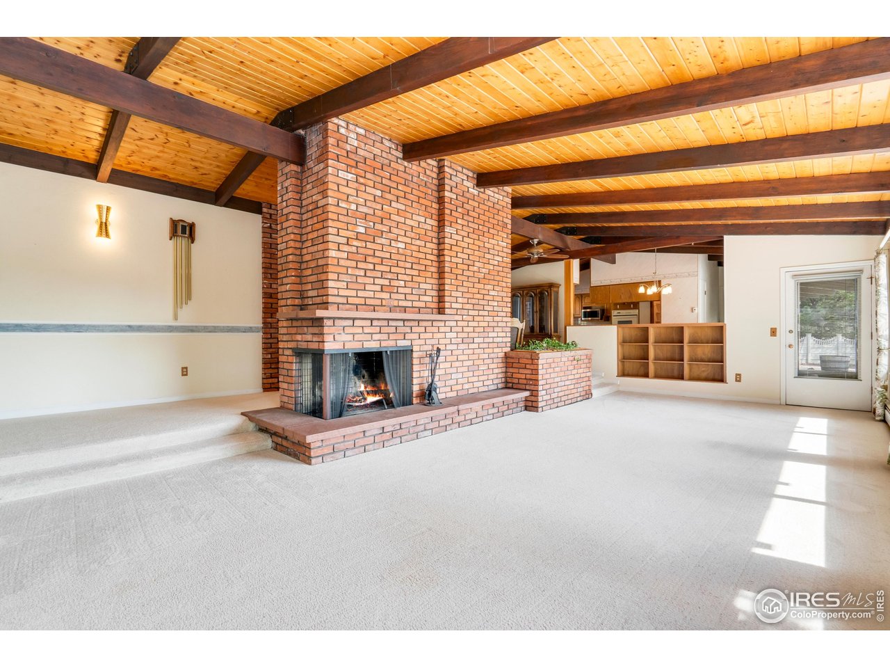 2115 Lindenmeier Road Fort Collins, CO 80524 - Photo 18 of 28 a view of an empty room with wooden floor and a fireplace
