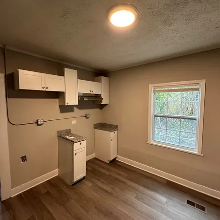 a view of a kitchen with wooden floor and electronic appliances