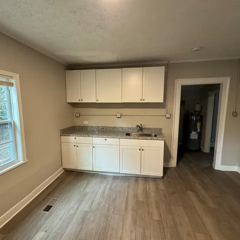 a kitchen with granite countertop white cabinets and white appliances