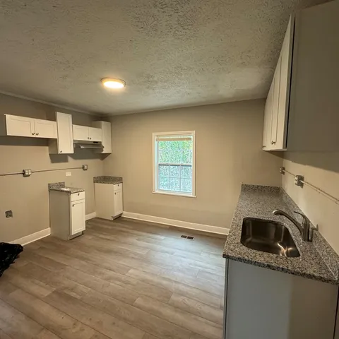 a kitchen with a sink stove top oven and cabinets