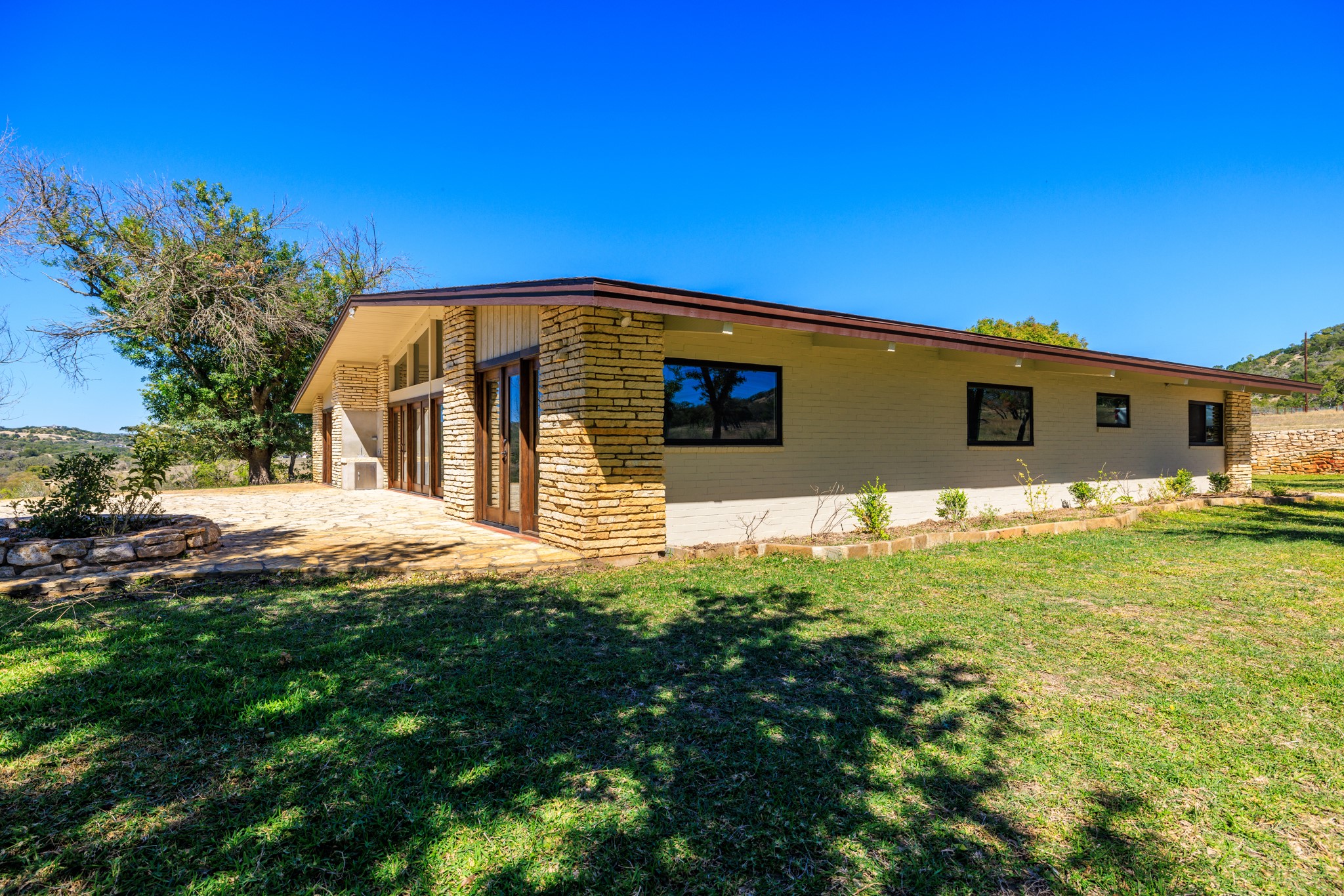 241 Highway 87 Comfort, TX 78013 - Photo 28 of 39 View of home's exterior with a lawn, driveway, stone siding, and an attached garage