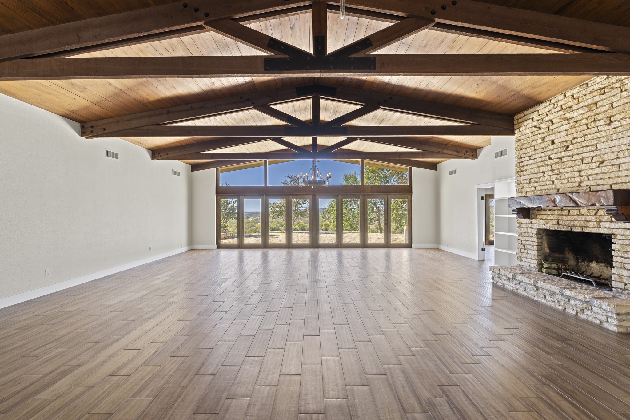 241 Highway 87 Comfort, TX 78013 - Photo 6 of 40 a view of an empty room with wooden floor a fireplace and a window