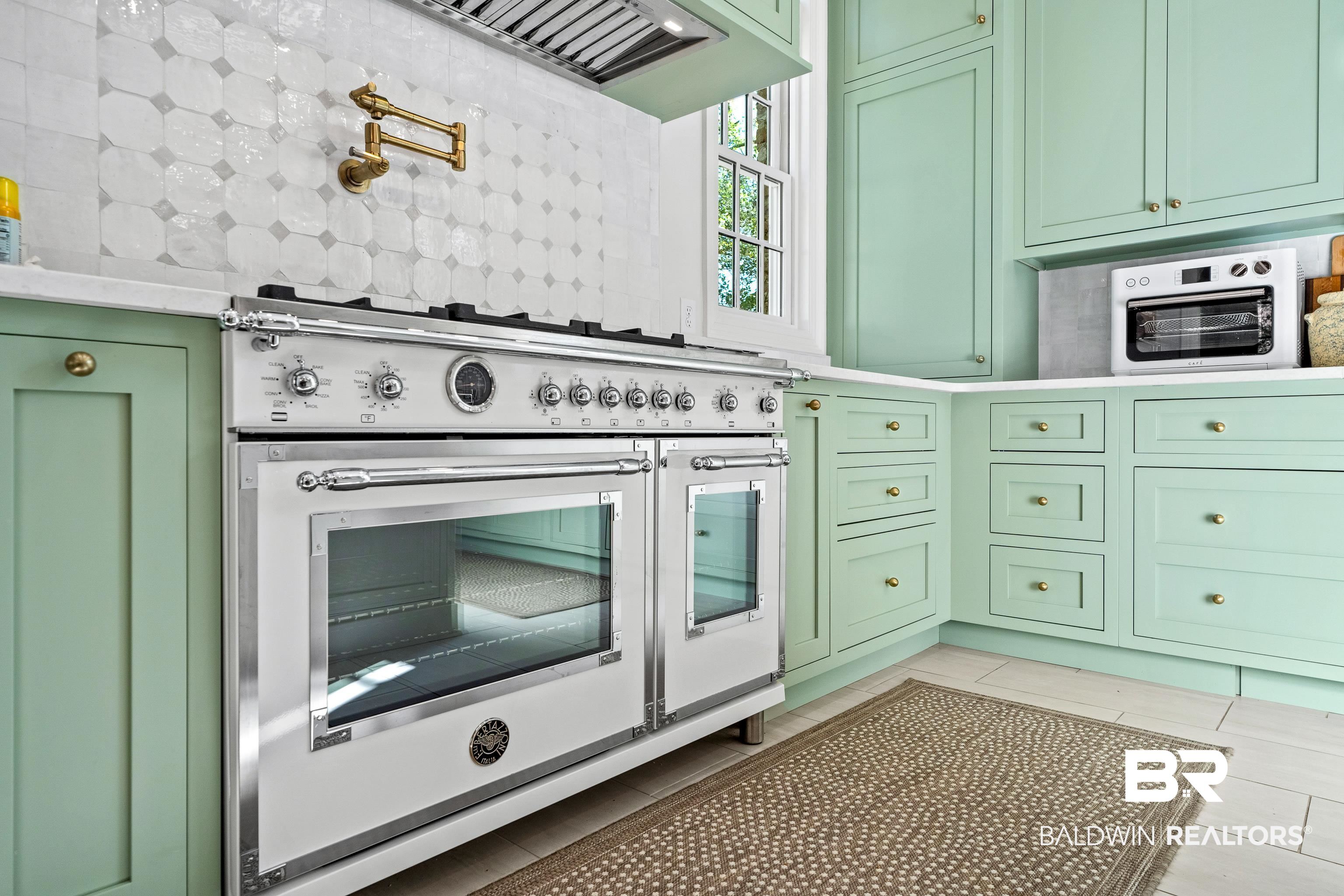 141 Myrtlewood Lane Mobile, AL 36608 - Photo 12 of 44 Kitchen with green cabinets, light countertops, tasteful backsplash, premium range hood, and range with two ovens
