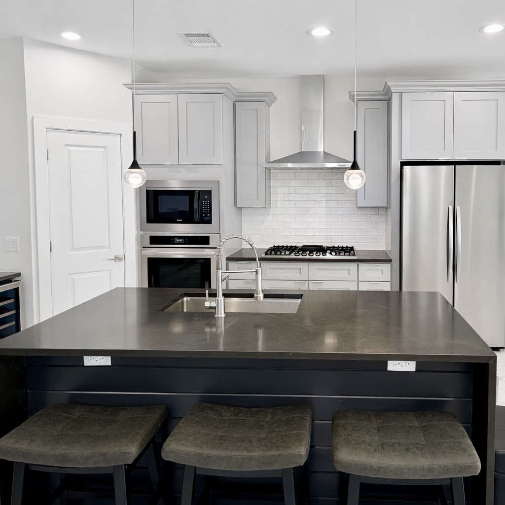 10115 Porto Rico Road Houston, TX 77041 - Photo 8 of 17 a kitchen with kitchen island a stove a refrigerator a sink and a stove with wooden floor
