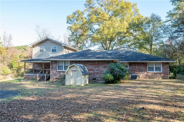a view of a house with swimming pool next to a yard
