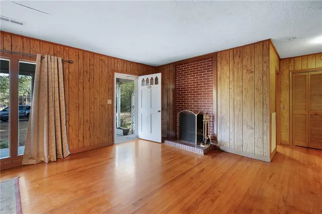 an empty room with wooden floor and entryway