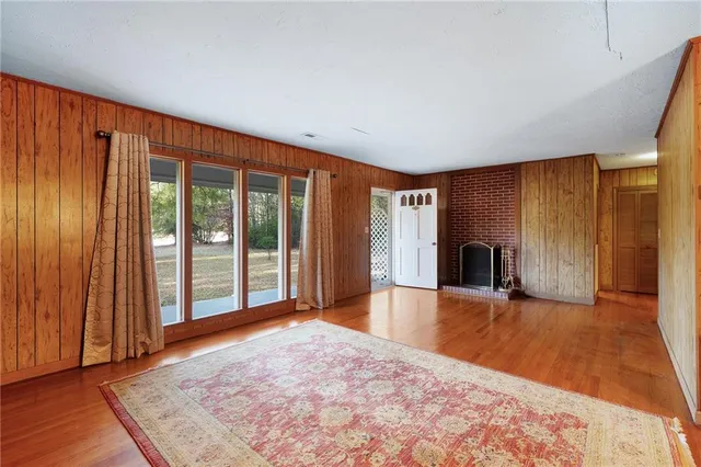 a view of an empty room with window and wooden floor