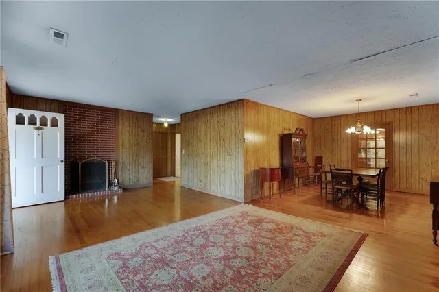 a living room with furniture a dining table and kitchen view with wooden floor