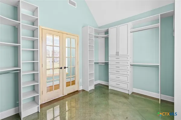 a view of walk in closet with empty racks