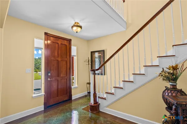 a view of entryway with wooden floor and stairs