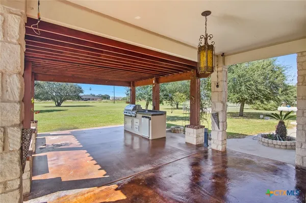 a view of a patio with a table chairs potted plants and a palm tree