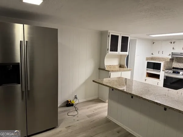 a kitchen with stainless steel appliances granite countertop a refrigerator and a sink