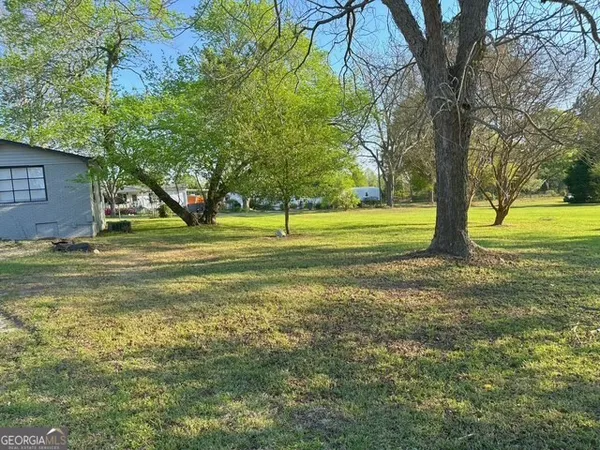 a view of a big yard with large trees