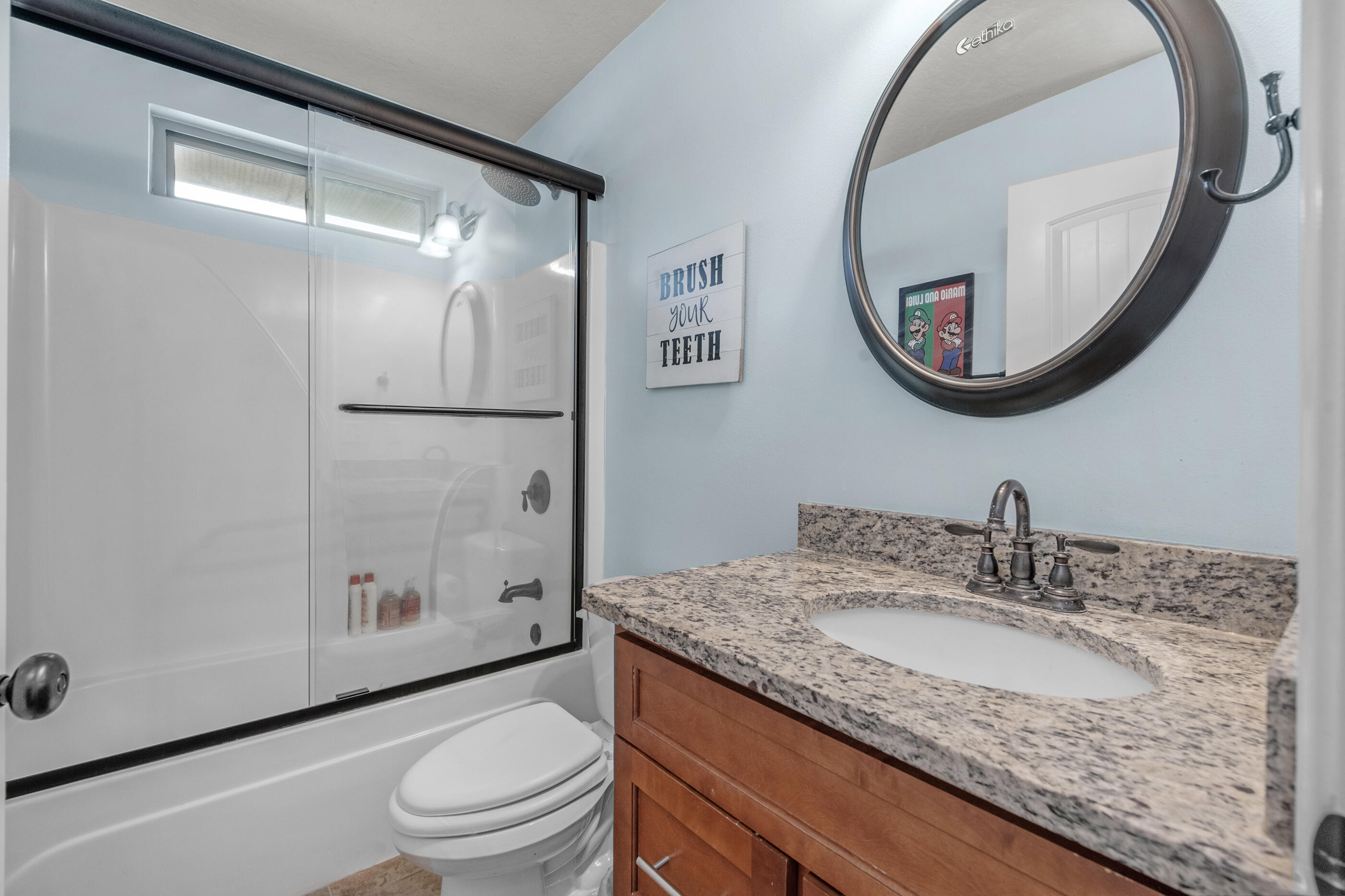 4509 Beth Circle Crestview, FL 32539 - Photo 13 of 29 a bathroom with a granite countertop sink toilet and a mirror
