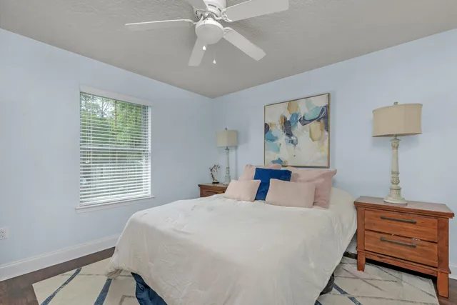 a bedroom with a bed and a lamp on dresser
