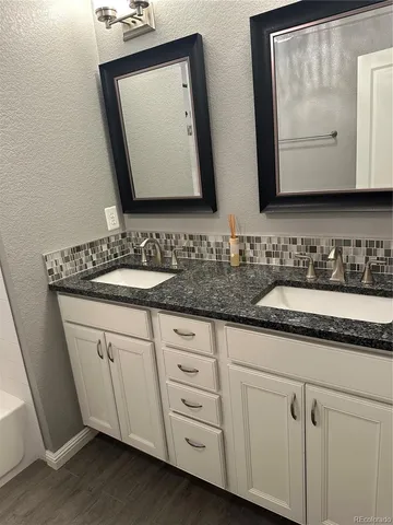 a bathroom with double sink and a mirror