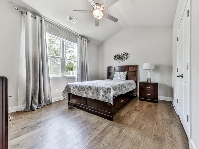 a bedroom with a bed a window and a chandelier