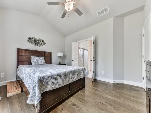 a bedroom with bed and wooden floor