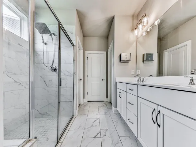 a spacious bathroom with a double vanity sink mirror and shower