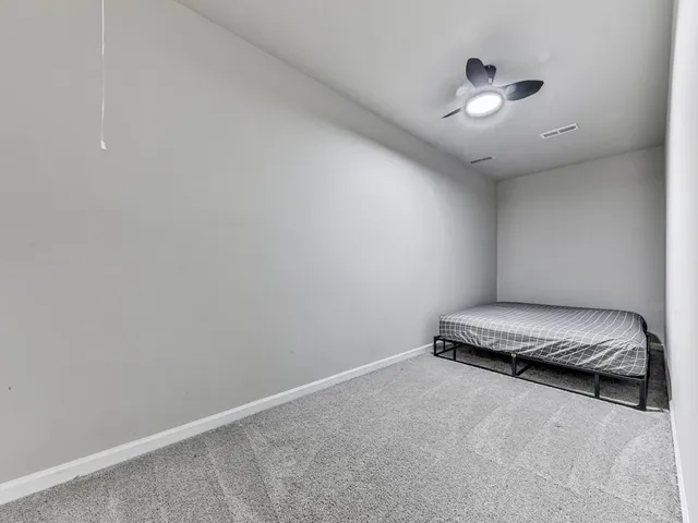 an empty room with a chandelier fan